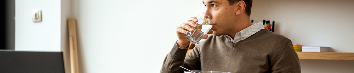 Mann trinkt aus einem Glas