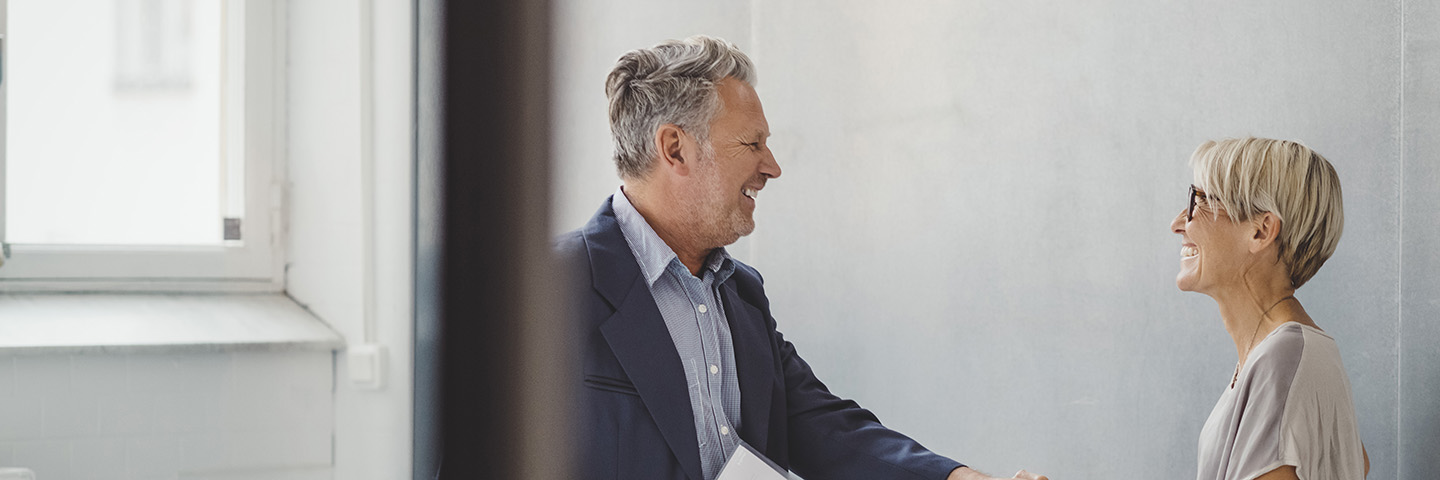 Durch BEM handelt der Arbeitgeber fürsorglich im Interesse seiner Arbeitnehmer Zwei Mitarbeiter begrüßen sich