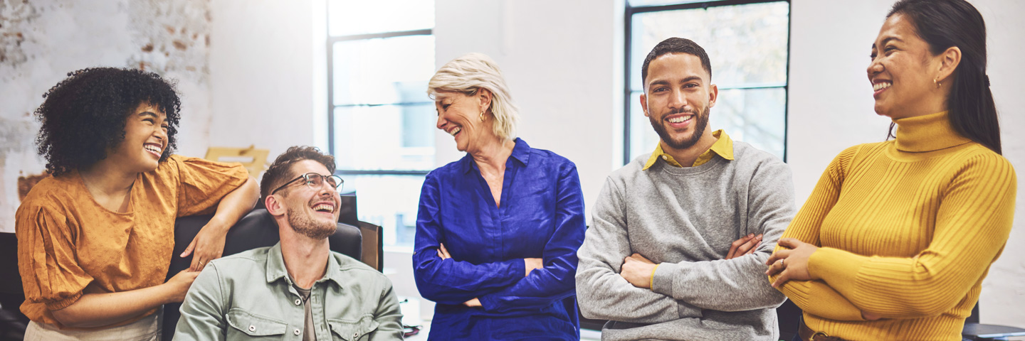 AOK für Arbeitgeber: Gut gelaunte Menschen in einem Besprechungsraum