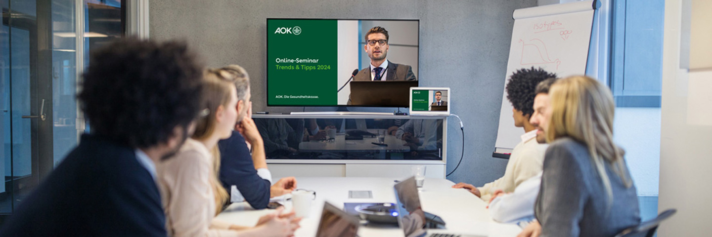 Trends & Tipps 2024 – Neues in der Sozialversicherung Teilnehmende eines Trends & Tipps Online-Seminars sitzen an einem Tisch und schauen sich die Präsentation an.