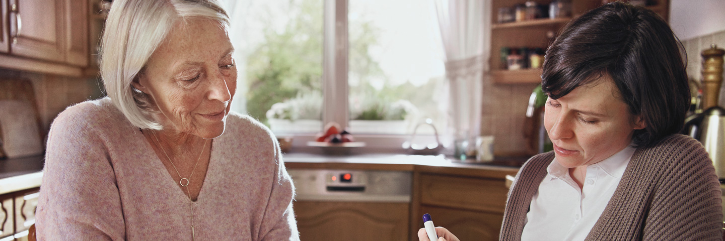 Nachweis der Elterneigenschaft für die Pflegeversicherung: Tochter mit pflegebedürftiger Mutter in einer Küche.