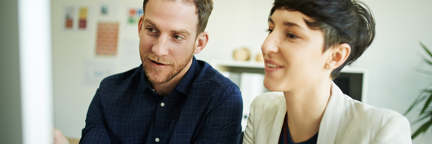 Trends & Tipps 2027 – Neues in der Sozialversicherung: eine Frau und ein Mann schauen gemeinsam in einen Bildschirm.