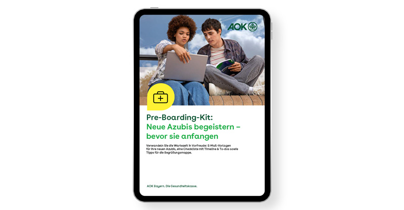 Das Titelblatt des AOK-Pre-Boarding-Kits zeigt zwei Auszubildende, die im Freien vor einem Laptop sitzen und etwas besprechen.