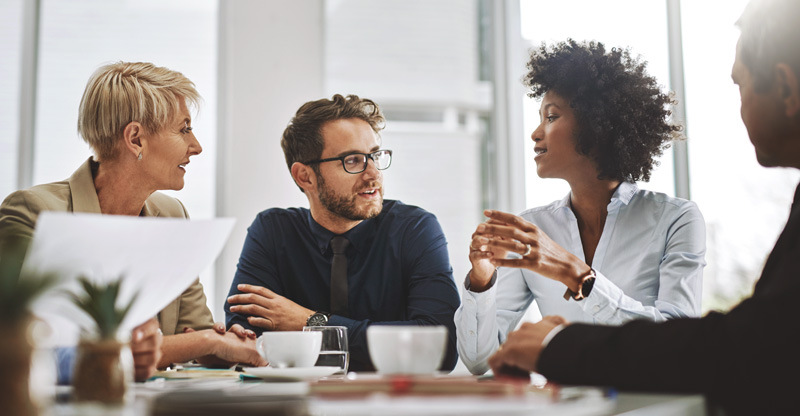 Ansprechpartner für Ihr Unternehmen Vier Menschen in einer Besprechung im Büro