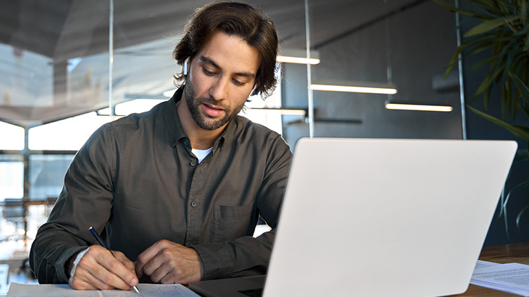 Ein Mann sitzt am Laptop und recherchiert im AOK Expertenforum.