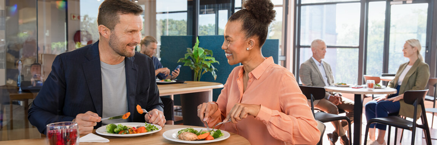 Ein Mann und eine Frau essen in einer Kantine – eine gesunde Gewohnheit. Ein Mann und eine Frau essen in einer Kantine – eine gesunde Gewohnheit.