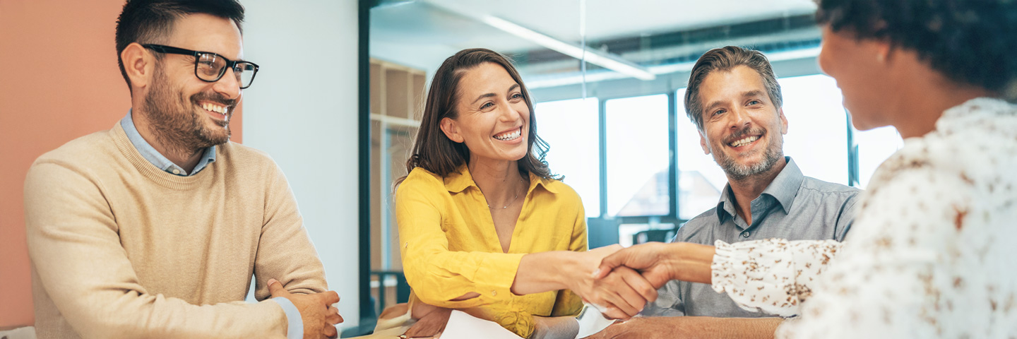 Onboarding für Fachkräfte: Ein Team begrüßt eine neue Kollegin freundlich mit Handschlag