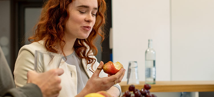 Abschalten vom Job Beschäftigte im Büro machen gemeinsam eine Pause und essen Obst.