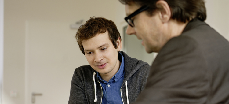 Neues in der betrieblichen Ausbildung: Konjunkturpaket und Mindestvergütung Ein junger Mann im Gespräch mit einem älteren Mann.