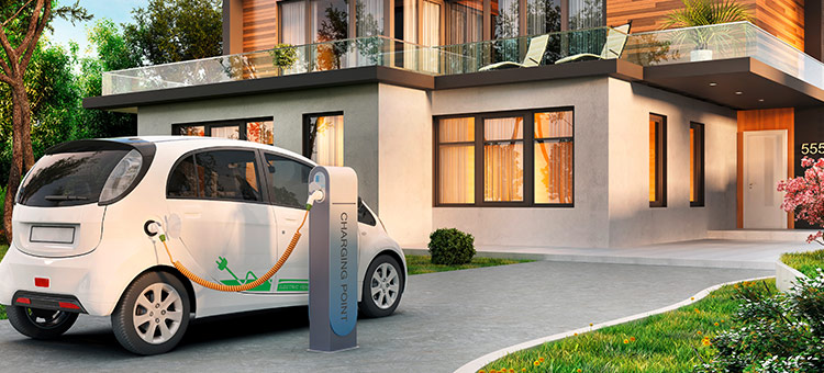 Steuerliche Besonderheiten bei Elektrodienstwagen Ein Elektroauto wird an einer Ladesäule vor einem Haus aufgeladen.