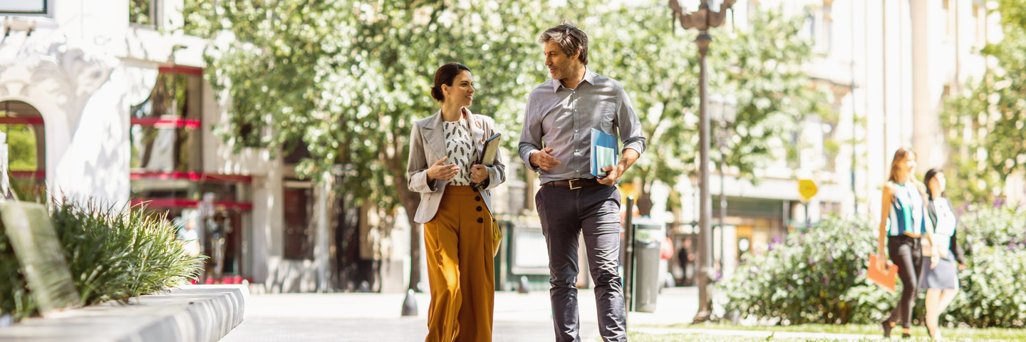 Outdoor-Impulse im Arbeitsalltag: zwei Beschäftigte im Austausch bei einem Spaziergang im Freien