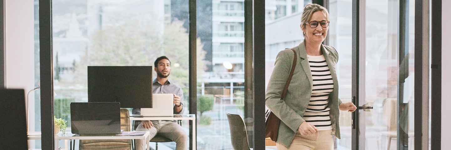 Grenzmanagement: Eine Frau verlässt gut gelaunt ein Büro. Grenzmanagement: Eine Frau verlässt gut gelaunt ein Büro.