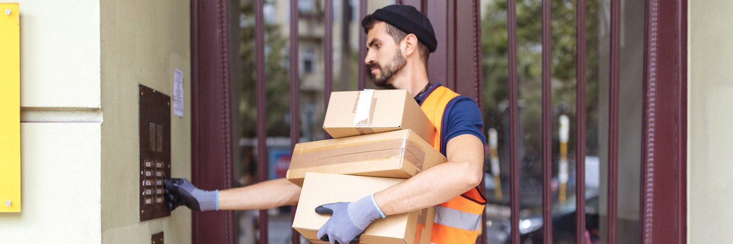 Basisarbeitende wertschätzen: Paketlieferant klingelt an einem Wohnhaus Basisarbeitende wertschätzen: Paketlieferant klingelt an einem Wohnhaus