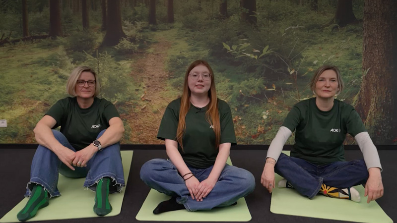 Progressive Muskelentspannung: drei Frauen sitzen auf Yogamatten 