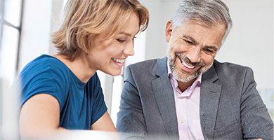 Online-Seminar „Betriebliches Eingliederungsmanagement (BEM) – Leistungen und Fördermöglichkeiten“ Frau und Mann am Bürotisch im offenen Gespräch.
