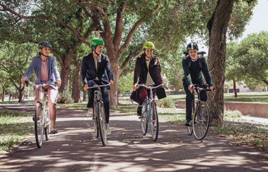 Klimabewusstes Unternehmen: vier Menschen auf dem Fahrrad unterwegs im Grünen