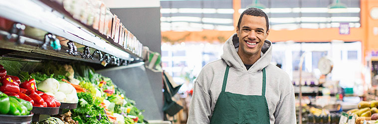 Online-Seminar „Minijobs“ Ein Einzelhandelskaufmann räumt ein Supermarktregal ein.