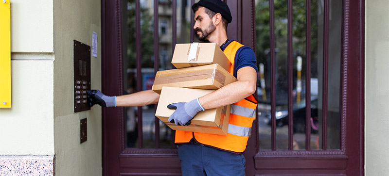 Basisarbeitende wertschätzen: Paketlieferant klingelt an einem Wohnhaus
