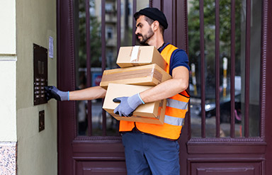 Basisarbeitende wertschätzen: Paketlieferant klingelt an einem Wohnhaus