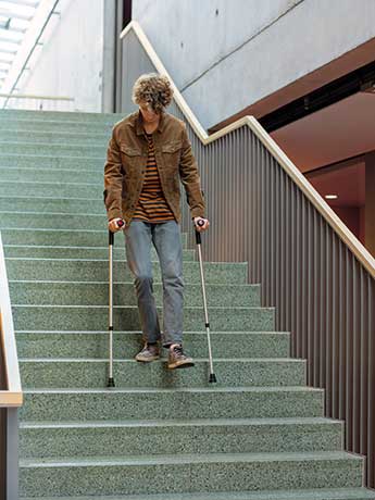 Entgeltfortzahlung im Krankheitsfall regelt das Entgeltfortzahlungsgesetz Ein Kranker geht mit Krücken eine Treppe hinunter