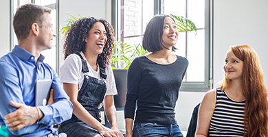 Online-Training Krankenkassenwahlrecht Eine Gruppe junger Leute sitzt zwanglos in einem Büro zusammen.