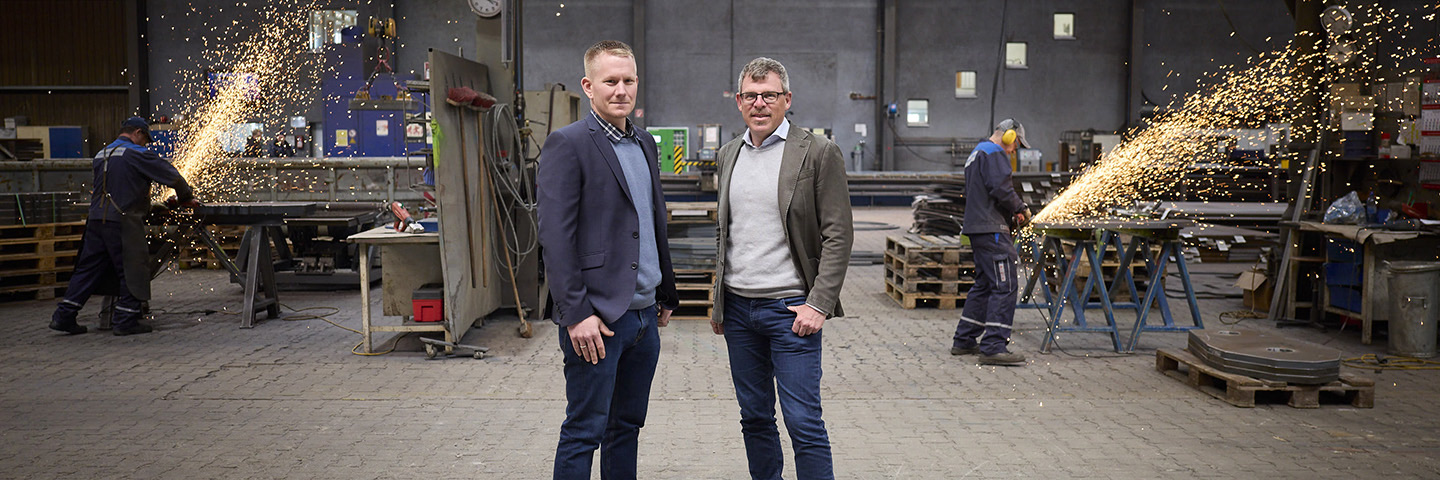 Best Practice BGF: BGM-Beauftragter André Jantzen und Geschäftsführer Thomas Wengler stehen in der Produktionshalle.