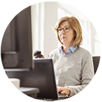 Eine Frau sitzt vor ihrem Monitor in einem Büro.