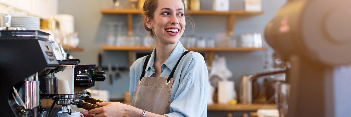Minijobs Frau arbeitet im Café an Espressomaschine.