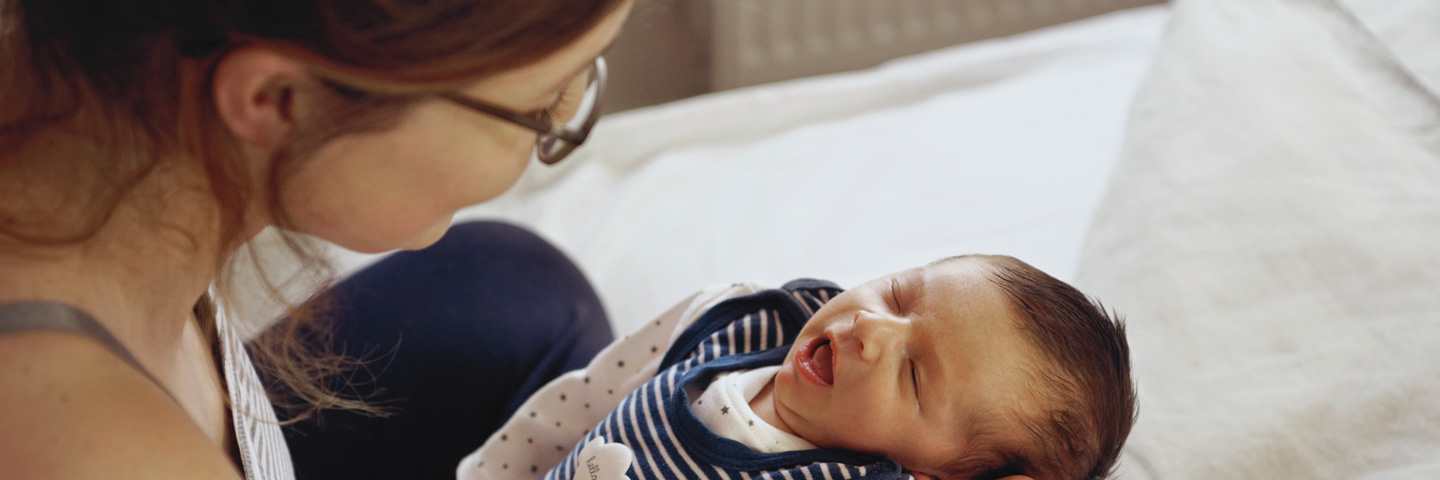 Mutterschutz und Ausgleichsverfahren U2: Junge Mutter hält ein Baby im Arm