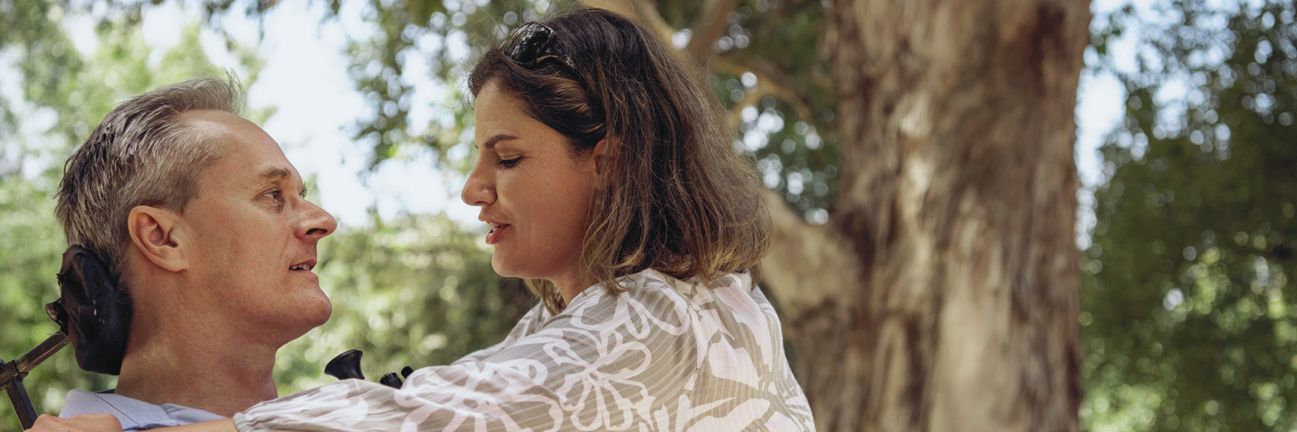 Eine Frau kümmert sich um Mann im Rollstuhl: Pflegeversicherung