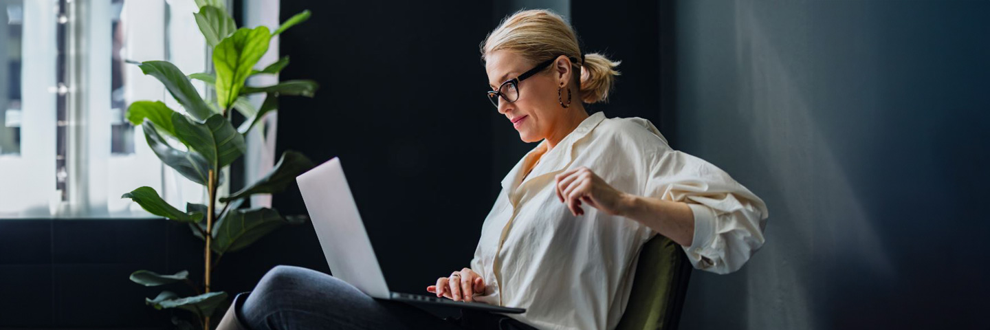 Eine Frau schaut in einen Laptop.