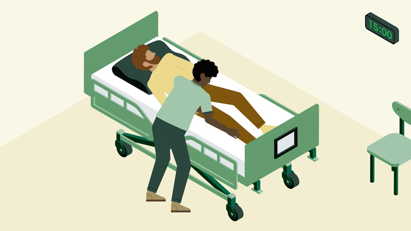 Ergonomische Grundsätze in Pflegeberufen: Ein Pfleger bettet einen Patienten in einem Krankenbett.