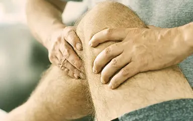Therapeut behandelt Knie eines Patienten