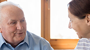Weibliche Pflegekraft hilf älteren Mann beim Ausfüllen von Dokumenten
