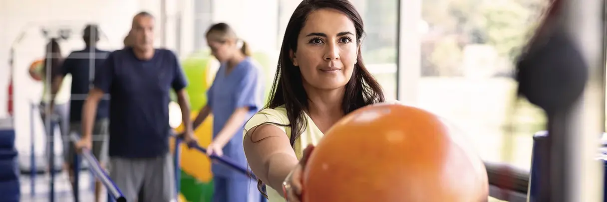 Frau mit ausgestreckten Armen hält einen Ball
