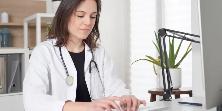 Ärztin tippt eine Nachricht am Computer