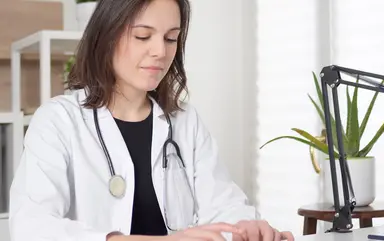 Ärztin tippt eine Nachricht am Computer