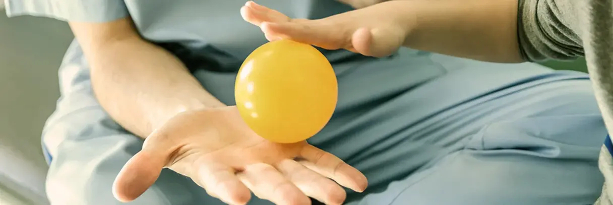 Ergo Frau Kind Hand Ball Ergotherapeut und Kind, haben in einer Hand mit einem kleinen Ball und machen Übung