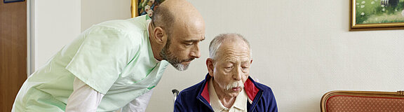 Altenpfleger pflegt älteren Mann (Symbolbild)
