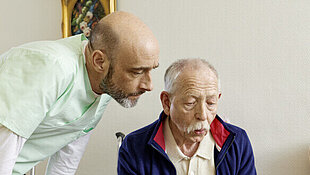 Altenpfleger pflegt älteren Mann (Symbolbild)