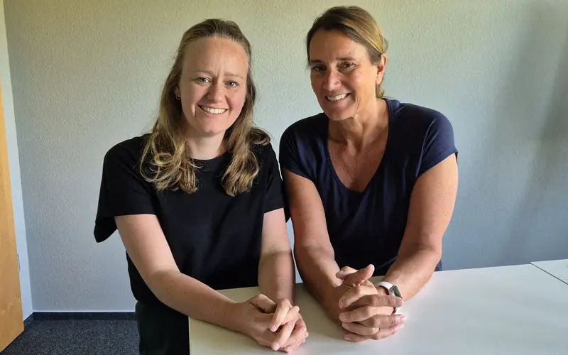 Judith Meemken und Kristina Tatenhorst, beratende Apothekerinnen der AOK Niedersachsen Judith Meemken und Kristina Tatenhorst sitzen an einem Tisch und lächeln. Die beratenden Apothekerinnen der AOK Niedersachsen erläutern für den Podcast AOK Praxis-Talk die Grundlagen des Festbetragssystems.