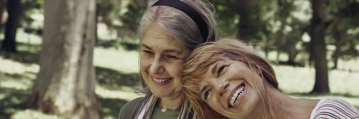 Zwei Frauen im Alter von 60 bis 70 Jahren. Eine stützt die andere. Beide lachen. Zwei Frauen im Alter von 60 bis 70 Jahren. Eine stützt die andere. Beide lachen.