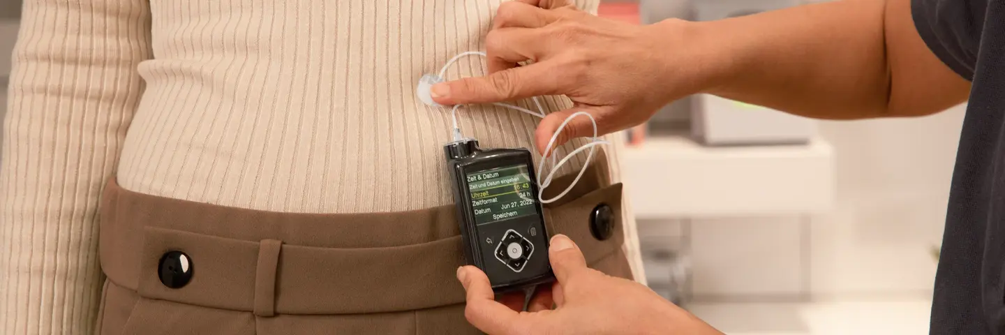 Person misst mithilfe eines Messfühlers Werte einer Patientin