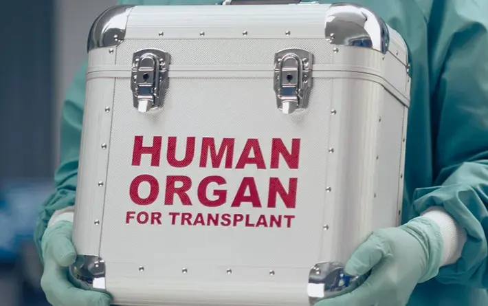 Foto: Mann transportiert Spenderorgan in einem Spezialbehälter