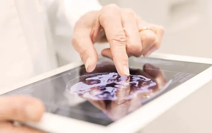 Foto: Hand tippt etwas auf einem Tablet-Display