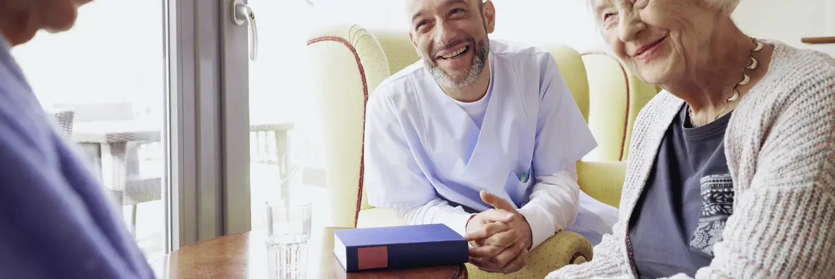 Altenpfleger spricht mit älterer Dame Altenpfleger spricht mit älterer Dame. Symbolbild für Pflege im Pflegeheim.