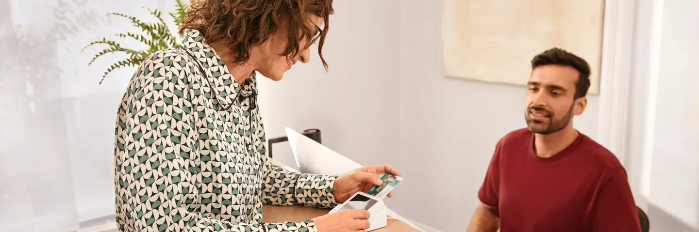 Eine Patientin meldet sich mit ihrer elektronischen Gesundheitskarte in der Arztpraxis an.