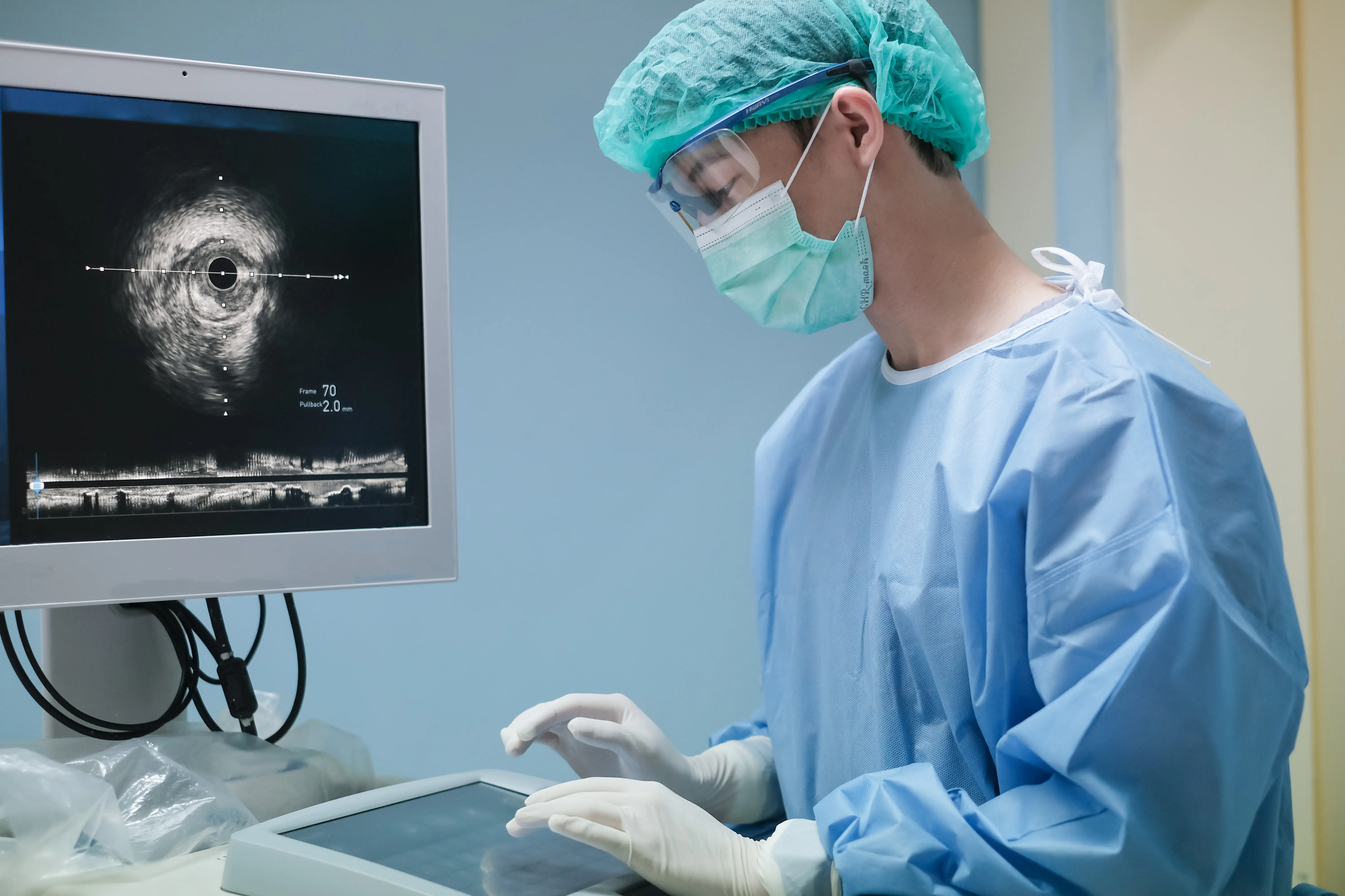 Arzt, der an der intravaskulären Ultraschallbildgebung (IVUS) im Herzkatheterlaborraum arbeitet.