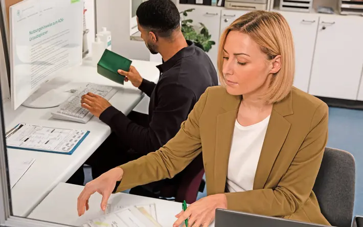 Zwei Mitarbeitende der Krankenhaus-Verwaltung bearbeiten Dokumente.