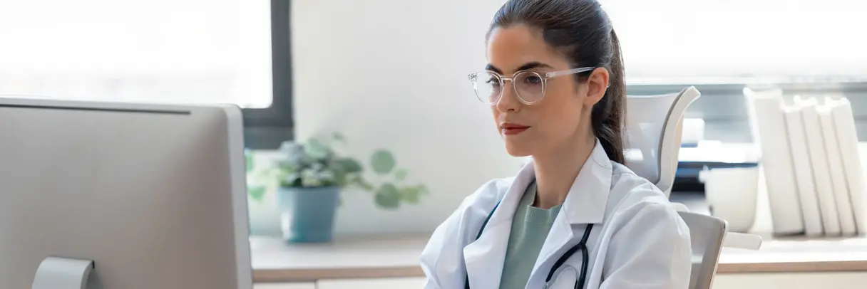 Das Bild zeigt eine Ärztin, die eine Nachricht am Computer verfasst.